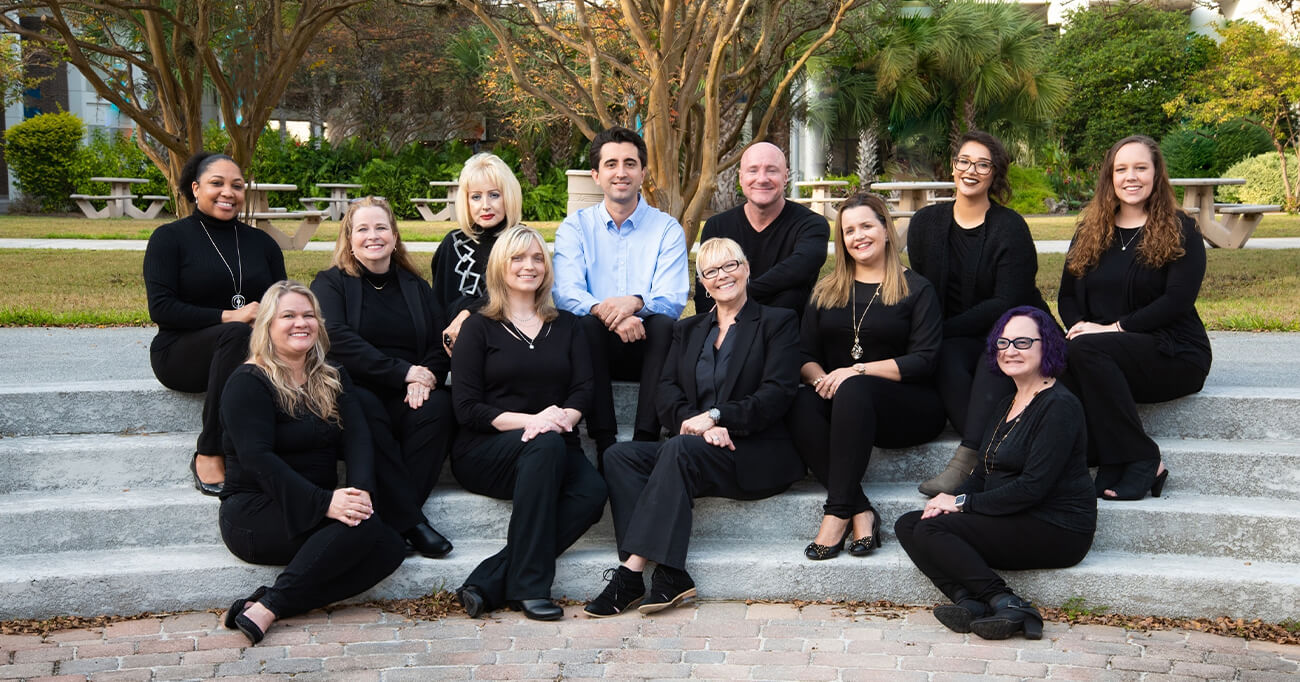 Jacksonville Florida dentist and dental team members sitting on stone staircase outdoors