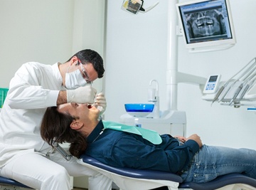 A dentist looking at a patient’s mouth