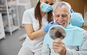 a patient checking their smile after getting dental implants