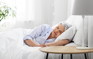 a woman resting after undergoing dental implant surgery