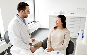 A young woman wearing a beige blouse listens to her doctor explain sleep apnea