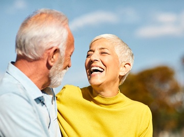 An older woman smiling and looking at her partner after seeing her Assurant Dental dentist in Jacksonville