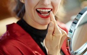 a person checking their teeth in the mirror