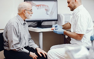 Dentist explaining the cost of dentures in North Jacksonville.