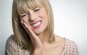 Distressed woman touching her cheek 