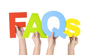 Hands holding up letters spelling FAQs