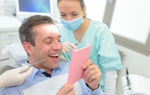 Man looking at his smile in the mirror