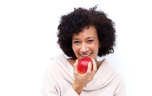 woman biting into a red apple