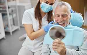 a patient checking their smile after getting dental implants