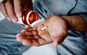 a man taking painkillers for dental implant post op instructions