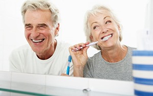 a mature couple brushing their teeth together