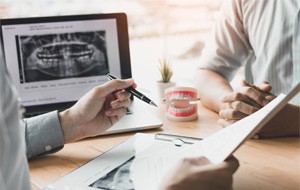 Closeup of dentist helping patient prepare for dental implant surgery in Jacksonville 