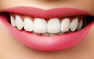 Close-up of perfect teeth surrounded by pink lips