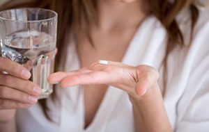 Woman preparing to swallow sedative pill