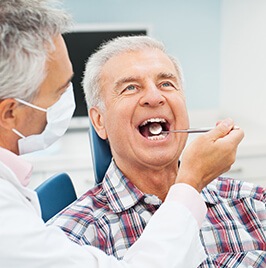 man in dental chair receiving checkup