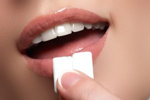 Closeup of woman putting gum in her mouth