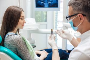 dentist showing patient dental implant