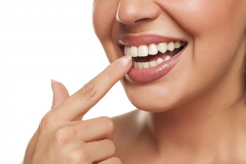 a woman pointing to her teeth