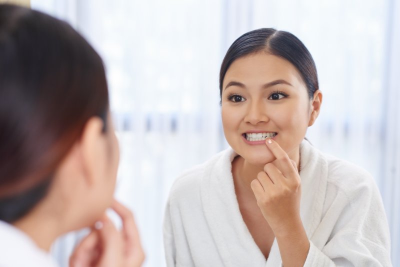 Woman checking her gums in the mirror