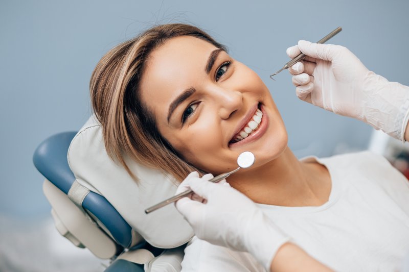 a young woman lying in the dentist’s chair undergoing a dental checkup and cleaning