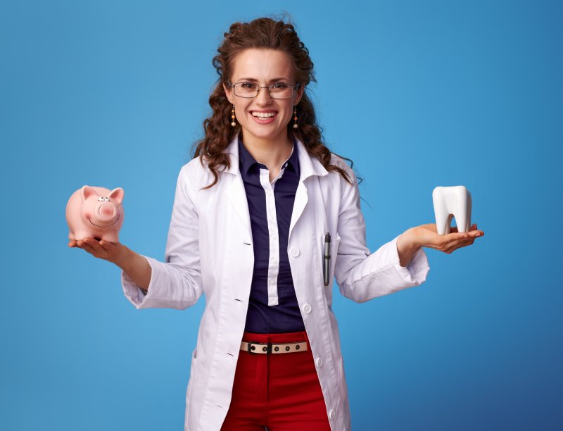 Doctor holding tooth and piggy bank.