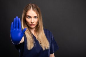 female dentist holding her hand up to say stop